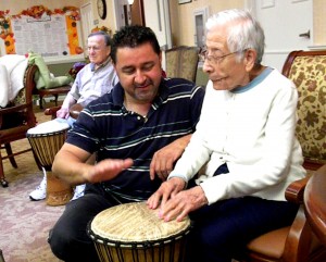A man teaching seniors to play bongos